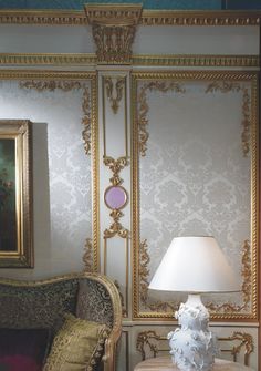 Wall Panels with damask and ornamentation and the space outside the panels has ornamentation.